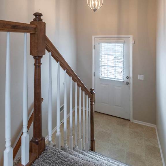 a light hanging from a ceiling in a room with a staircase.