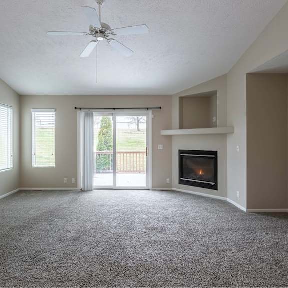 a living room with a fireplace and sliding glass doors.