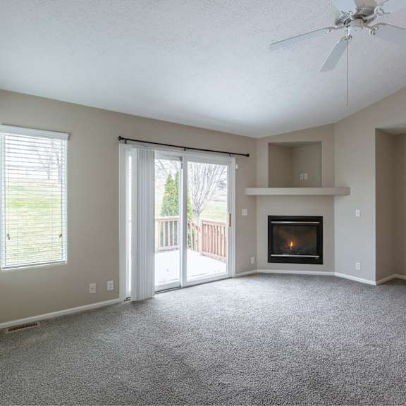 a living room with a fireplace and sliding glass doors.