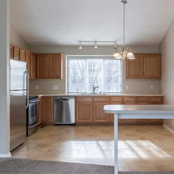 a kitchen with a white fridge and wooden cabinets.