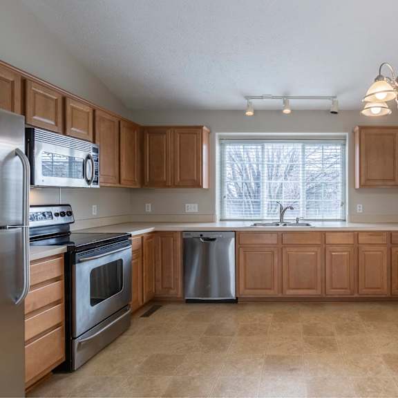a kitchen with wooden cabinets and stainless steel appliances.
