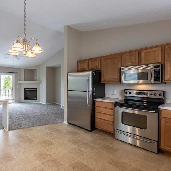 a kitchen with a stove, refrigerator, and microwave.