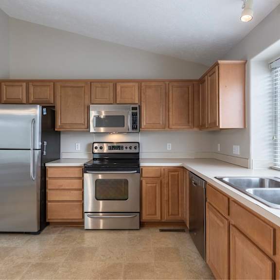 a kitchen with wooden cabinets and stainless steel appliances.