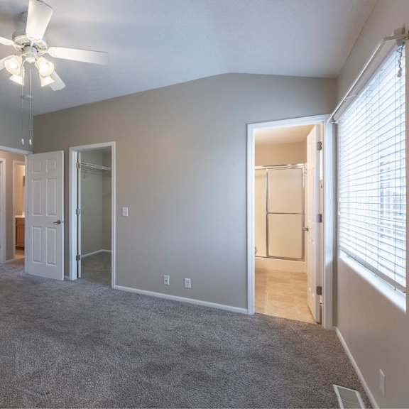 a room with a ceiling fan and carpeted floor.