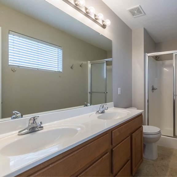 a bathroom with a white sink, toilet, and shower.