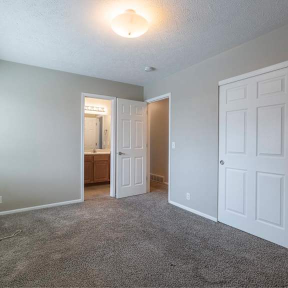 a room with white doors and carpeted floor.