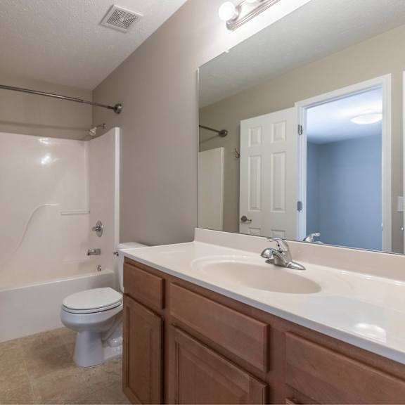 a white bathroom with a toilet, sink, and bathtub.