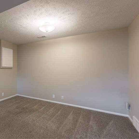 a room with a carpeted floor and a ceiling light.