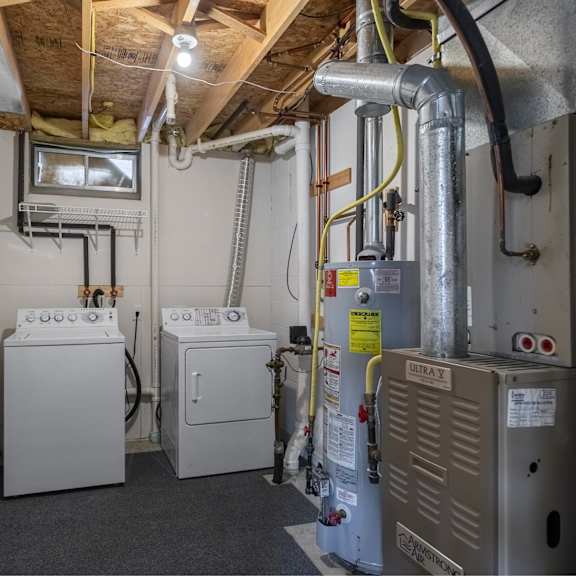 a utility room with a washer and dryer, a furnace, and a water heater.