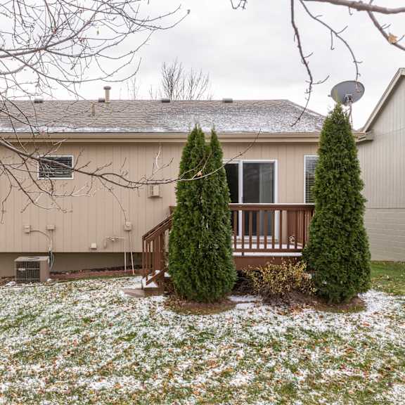 a house with a brown roof and a white fence.