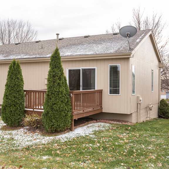 a house with a grey roof and a brown fence.