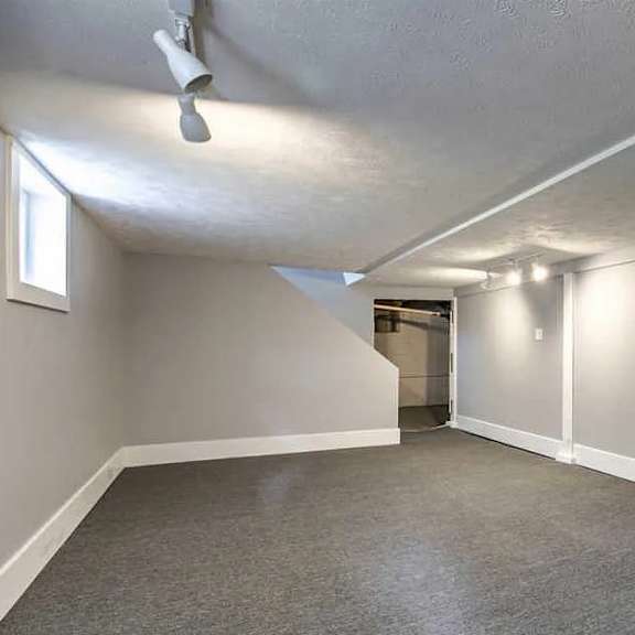 a room with a ceiling fan and a doorway leading to another room.