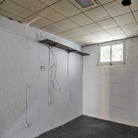 a white bathroom with a window and a shower.