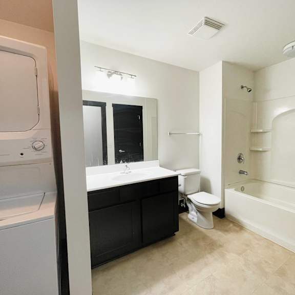 a white bathroom with a washer and dryer.