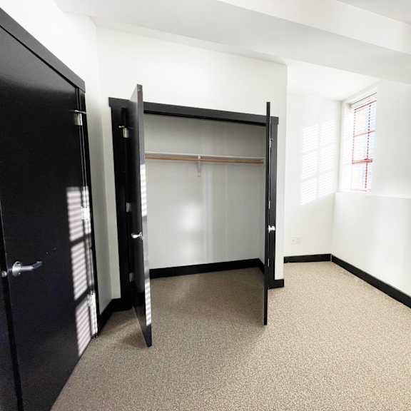 a room with a black closet and a carpeted floor.