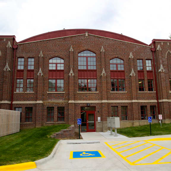a red brick building with a red roof and a parking lot in front.
