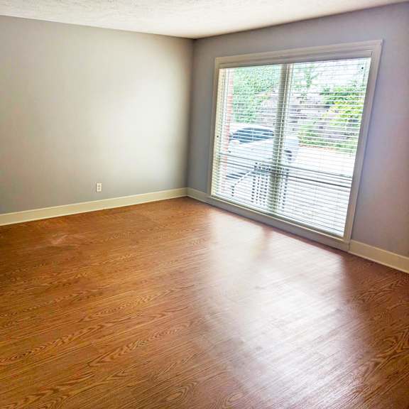 a room with a wooden floor and a sliding glass door.