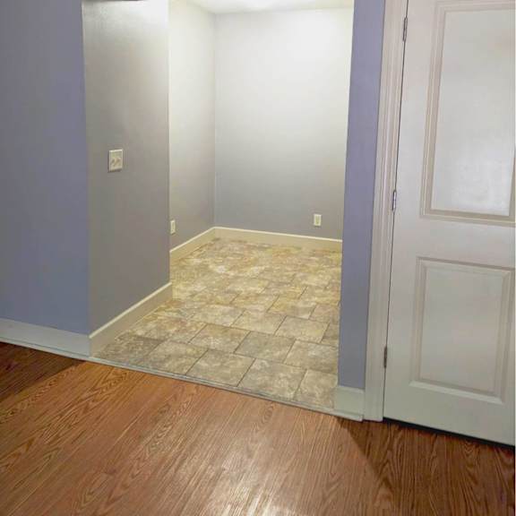 a room with a tiled floor and a white door.