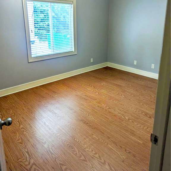 a room with a ceiling fan and a window with blinds.