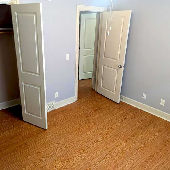 a room with two doors and a wooden floor.