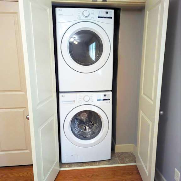 a white washing machine is in a doorway.