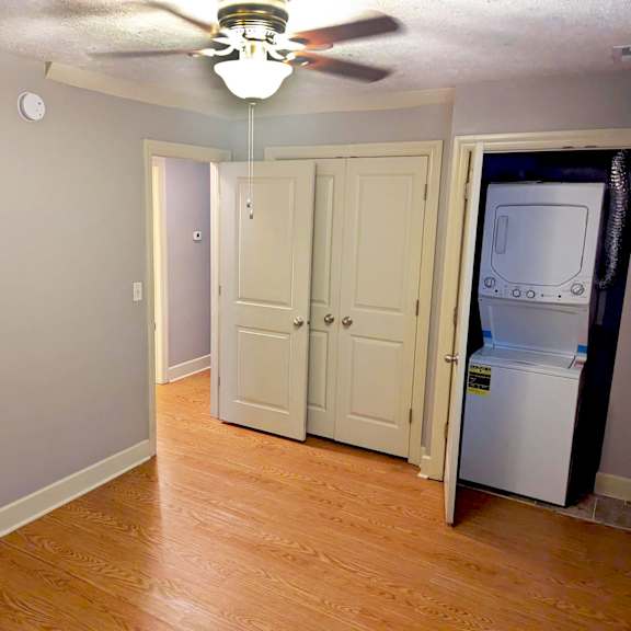 a room with a ceiling fan and a refrigerator in it.