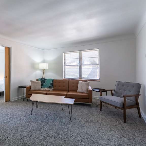 a bedroom with a bed, couch, and chair.