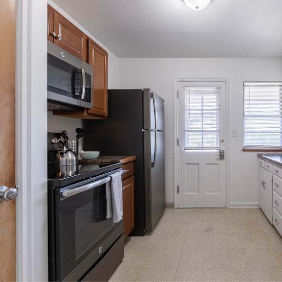 a kitchen with black appliances and white cabinets.