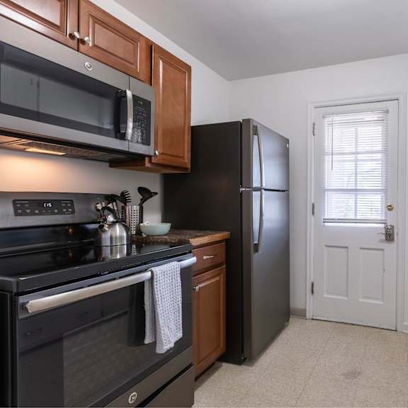 a kitchen with black appliances and white cabinets.