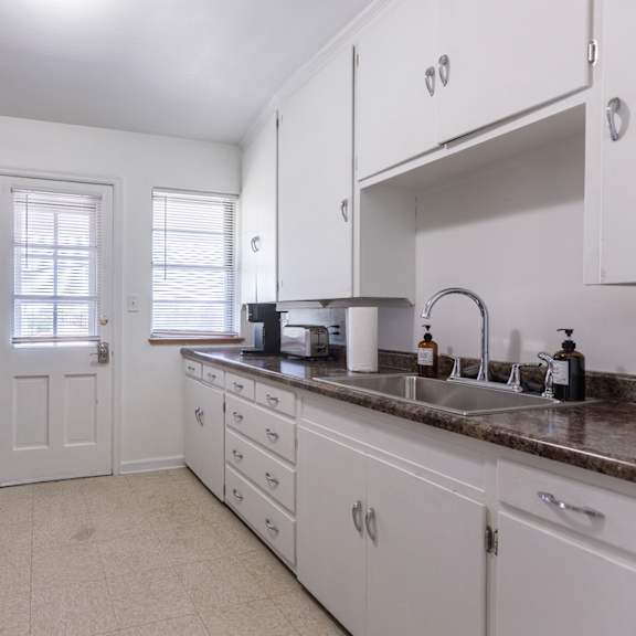 a kitchen with black appliances and white cabinets.