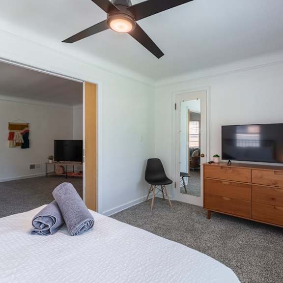 a bedroom with a bed, chair, and television.