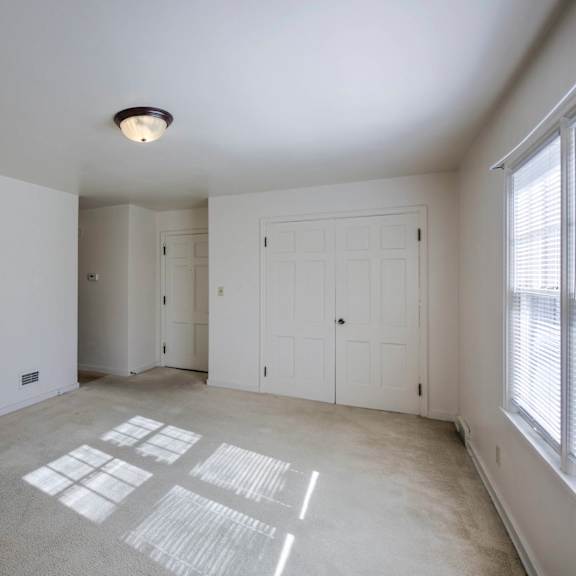 a room with white walls and a window on the right side.