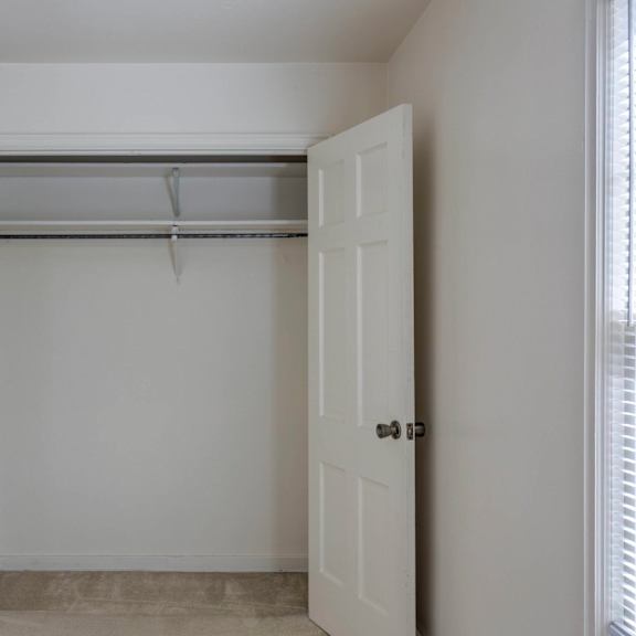a white door is open to a room with a white wall and a white ceiling.