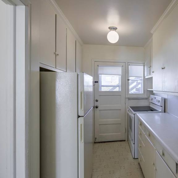 a kitchen with white cabinets and appliances.