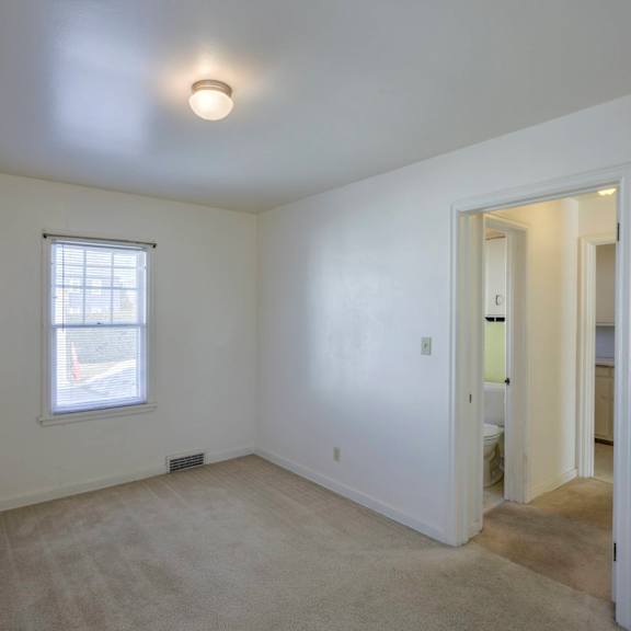 a white room with a window and a door.