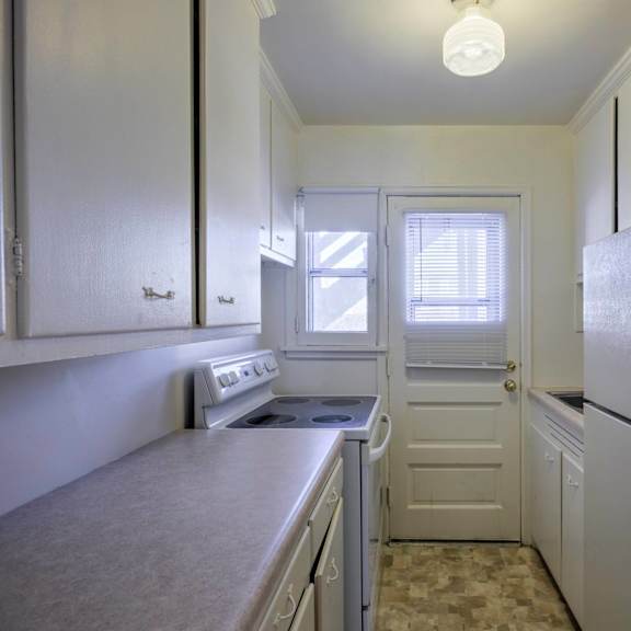 a kitchen with white cabinets and a refrigerator.