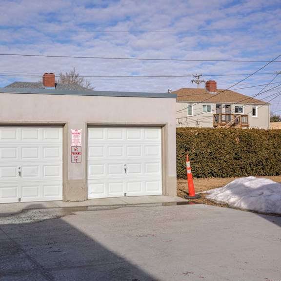 a building with two garage doors and a sign on the right door.