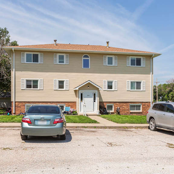a two-story house with a car parked in front.