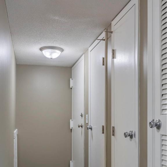a row of white doors in a hallway.