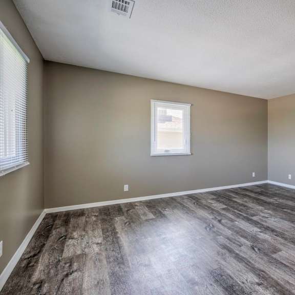 a room with a window and a wooden floor.