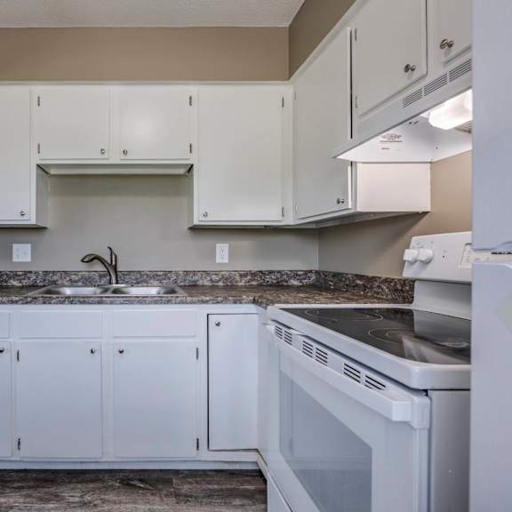 a kitchen with white cabinets and a granite countertop.