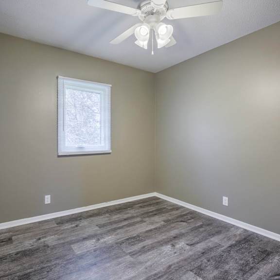 a room with a ceiling fan and a window.
