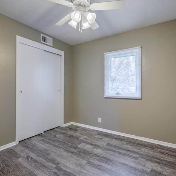a room with a ceiling fan and a window.