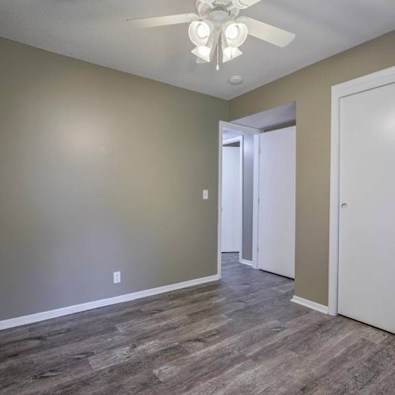 a room with a ceiling fan and a white door.