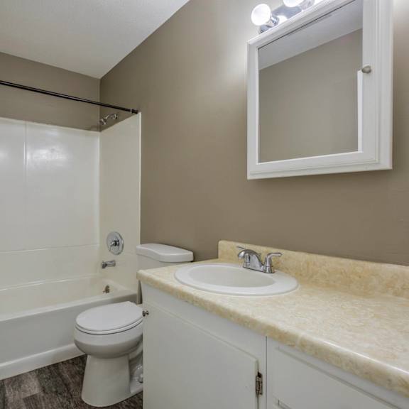 a white bathroom with a toilet, sink, and bathtub.