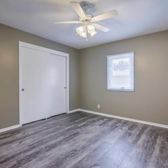 a room with a ceiling fan and a window.
