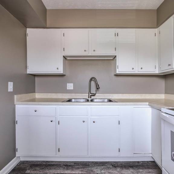 a kitchen with white cabinets and a white sink.