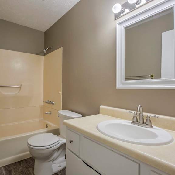 a bathroom with a toilet, sink, and bathtub.