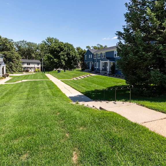 a grassy lawn leads to a row of houses.