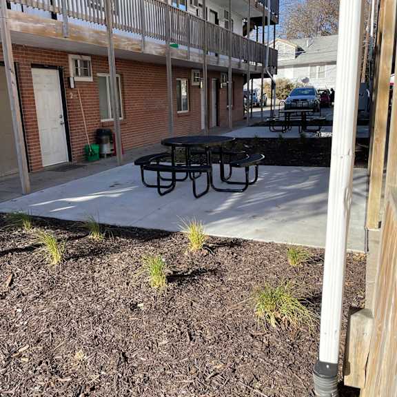 a black table is in the middle of a courtyard.